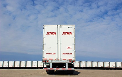 XTRA Lease dry van in foreground against blue sky with cumulocirrus clouds with edge to edge row of XTRA Lease dry vans in background